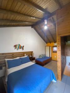 um quarto com uma grande cama azul num quarto em Pousada Cabanas Kaia Lua em Praia do Rosa