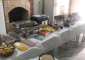 a buffet line with food on a table with a fireplace at POUSADA VISTA CHINESA in Rio de Janeiro