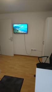 a room with a flat screen tv on a wall at Ferienwohnung Ehmen in Wolfsburg