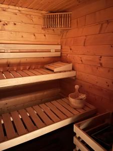 a wooden sauna with a bench and a basket in it at Villa Avril & spa, cinema, sauna & piscine - 15 Pers-proche Europapark in Sélestat