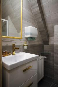La salle de bains est pourvue d'un lavabo blanc et d'un miroir. dans l'établissement Willa Za Potokiem, à Bukowina Tatrzańska