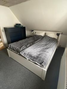 Cette petite chambre comprend un grand lit. dans l'établissement byhus centralt i bogense, à Bogense