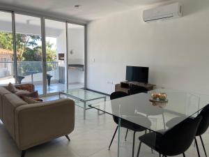 a living room with a glass table and a couch at Hermoso departamento con piscina y estacionamiento in Asuncion