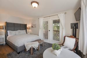 a bedroom with a bed and a chair and a table at Raven Point Inn in Ladysmith