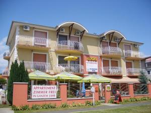 a large building with umbrellas in front of it at Unio Vendégház 2 in Siófok