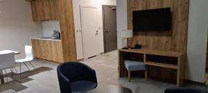 un soggiorno con TV, scrivania e sedie di Apartament Czarna Góra 419 a Sienna
