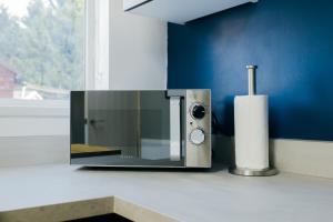 a microwave sitting on a counter next to a window at Rookwood house - spacious home with free parking - Short Stay Leeds in Killingbeck
