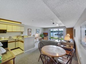 a kitchen and a living room with a table and chairs at 119 Edgewater Inn in Charlevoix
