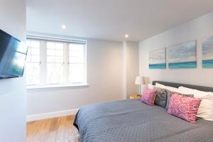 a bedroom with a bed and a tv and a window at Hampden Apartments - The Anne in Windsor