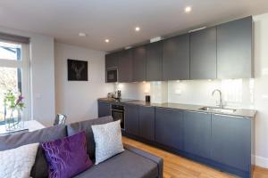 sala de estar con sofá y cocina en Hampden Apartments - The Anne en Windsor
