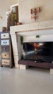 a living room with a television and a fireplace at Le Gîte des Rochettes, 600m à pied du Zoo de Beauval in Saint-Aignan