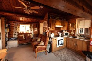 cocina con paredes de madera y techo en Country log cabin By Seren Property en Trawsfynydd