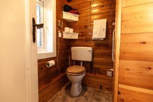 a bathroom with a toilet in a wooden wall at Rustic Log cabin in Snowdonia By Seren Short Stays in Trawsfynydd +8 photos
