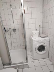 a bathroom with a shower and a washing machine at FeWo Alb-Traum in Albstadt