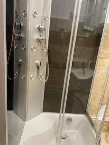 La salle de bains est pourvue d'une douche avec une porte en verre. dans l'établissement Casa Alex, à Câmpulung Moldovenesc
