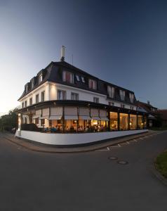 un gran edificio blanco con techo negro en Adler Hotel & Gasthaus, en Nonnenhorn