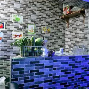 a kitchen with a blue brick wall and a counter with fruit at Elites Lodge in Port Harcourt