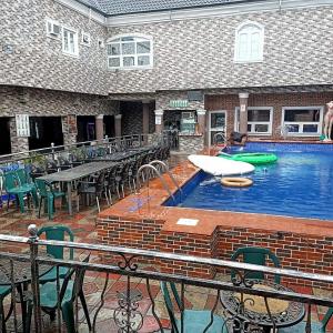 a large swimming pool with a table and chairs at Elites Lodge in Port Harcourt