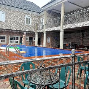 una piscina en una casa con mesa y sillas en Elites Lodge en Port Harcourt