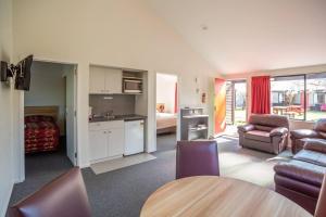a room with a kitchen and a living room at Christchurch Park Motel in Christchurch