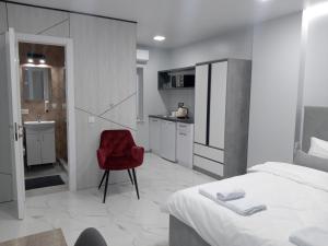 a bedroom with a red chair next to a bed at 39 Apart Hotel in Lviv