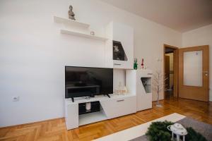 un soggiorno bianco con TV a schermo piatto di Harmonija 3 a Trebinje