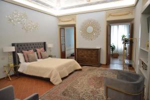 1 dormitorio con 1 cama grande y espejo en Campana Suites, en Bibbiena
