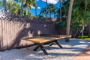 a wooden bench sitting next to a fence at NEWLY RENOVATED POOL, HOT TUB, & EPIC BACKYARD in Fort Lauderdale