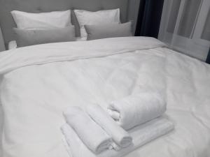 białe łóżko z ręcznikami i poduszkami w obiekcie 39 Apart Hotel w Lwowie