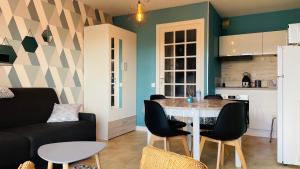 a kitchen and a living room with a table and chairs at Bel appartement au cœur de Stella-Plage in Cucq