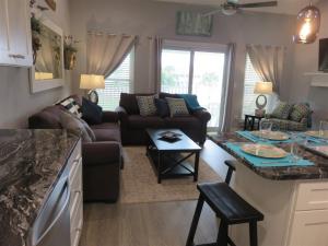 a kitchen and living room with a couch and a table at Our Happy Place in Destin
