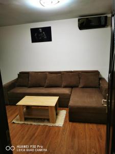 een woonkamer met een bank en een salontafel bij Închiriez garsoniera in Regim Hotelier Berceni-Sun Plaza in Boekarest