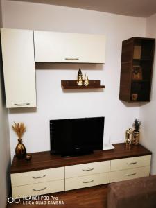 een woonkamer met een flatscreen-tv op een kast bij Închiriez garsoniera in Regim Hotelier Berceni-Sun Plaza in Boekarest