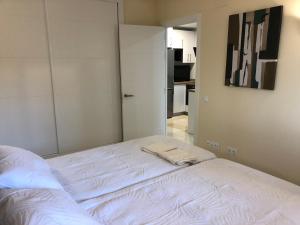福恩吉罗拉Moderno Apartamento en Primera línea Paseo Marítimo Fuengirola的客房内的白色床和2条毛巾