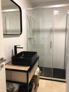 福恩吉罗拉Moderno Apartamento en Primera línea Paseo Marítimo Fuengirola的一间带黑色水槽和淋浴的浴室