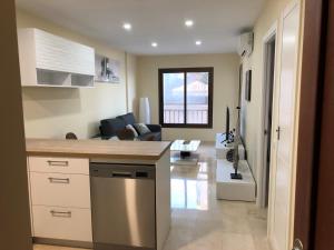 cocina y sala de estar con sofá en Moderno Apartamento en Primera línea Paseo Marítimo Fuengirola, en Fuengirola