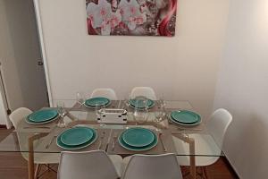 una mesa de comedor con platos y sillas verdes en Departamento Nuevo en Condominio Viña del Mar, en Viña del Mar