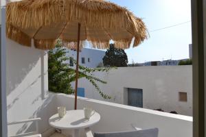 a white umbrella sitting on top of a white table at Artemis Hotel in Antiparos