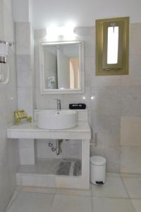 a bathroom with a sink, toilet and mirror at Artemis Hotel in Antiparos