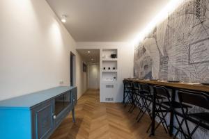 a bar with black chairs and a wall with a mural at Le Makè bed & breakfast in Campi Bisenzio