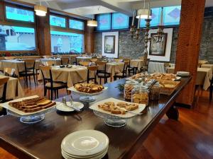 HG Hotel Italia في بروسون: طاولة عليها طعام في مطعم