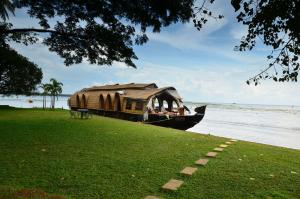 a boat parked on the grass near the water at Punnamada Resort in Alleppey