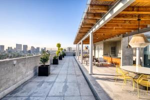 patio na dachu ze stołami i krzesłami oraz widokiem na miasto w obiekcie ULIV Polanco w mieście Meksyk