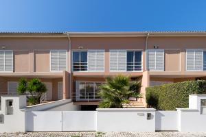 un edificio de apartamentos con vallas blancas delante de él en Casa do Suave Mar, en Esposende