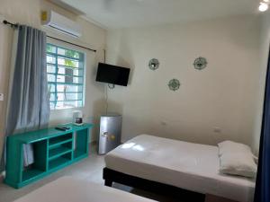 a room with two beds and a desk and a window at Bea rooms and studios in Cozumel