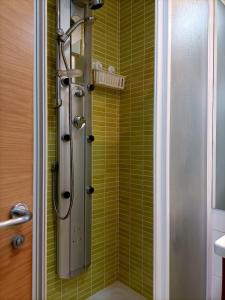 y baño con ducha y azulejos verdes. en Precioso spartamento, en Ramales de la Victoria