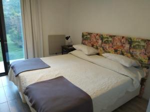 Schlafzimmer mit einem Bett mit einem Kopfteil und einem Fenster in der Unterkunft Mini casa in Chacras de Coria