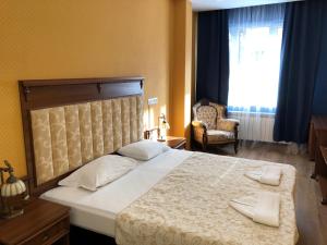 a bedroom with a bed and a chair and a window at APARTHOTEL BON BON in Sofia