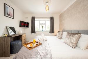 Un dormitorio con una cama con una bandeja de comida. en Treetops House -Luxury modern 4-bed, sleeps 10 -Solihull, JLR, NEC, Resorts World, Birmingham Airport, HS2, en Solihull