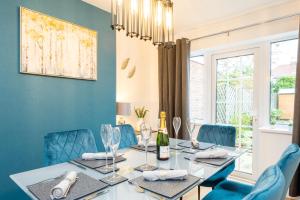 une salle à manger avec une table et des chaises bleues dans l'établissement Treetops House -Luxury modern 4-bed, sleeps 10 -Solihull, JLR, NEC, Resorts World, Birmingham Airport, HS2, à Solihull
